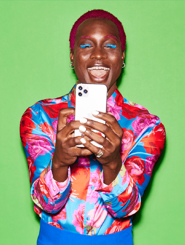 Un portrait d'une personne aux cheveux roses tenant un iPhone